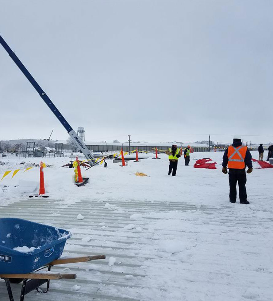 crew removing snow from a metal roof