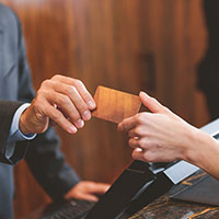 hotel clerk handing room key to a guest