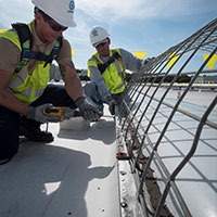 two roofers installing skylight screen